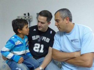 A surgeon from Healing the children meets with a patient and his father.
